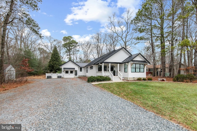 view of front of home featuring a garage, a front yard, and covered porch