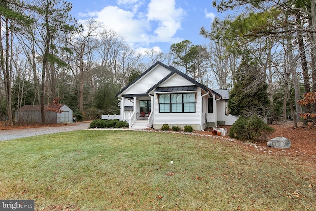 view of front of home featuring a storage shed, a front yard, and a porch