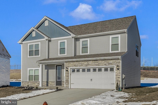 view of front of property featuring an attached garage, a shingled roof, stone siding, driveway, and board and batten siding