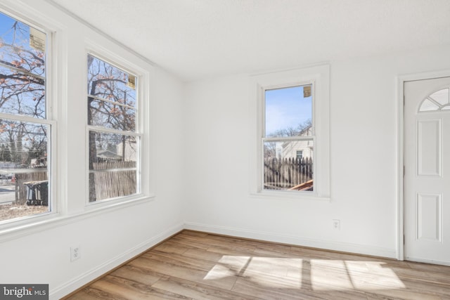 interior space featuring light wood-style flooring and baseboards