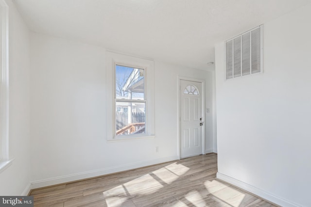 unfurnished room with baseboards, visible vents, and light wood finished floors