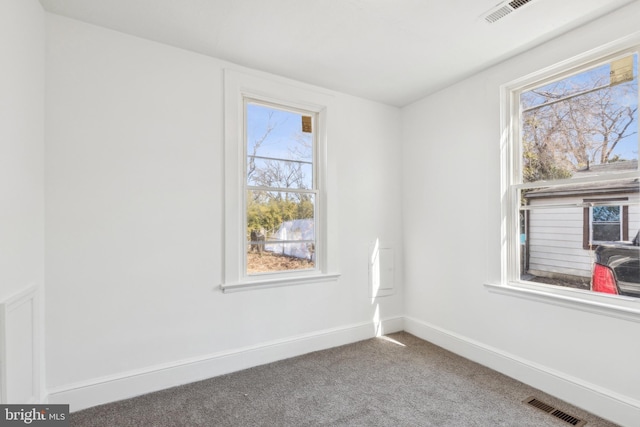 carpeted empty room with baseboards and visible vents