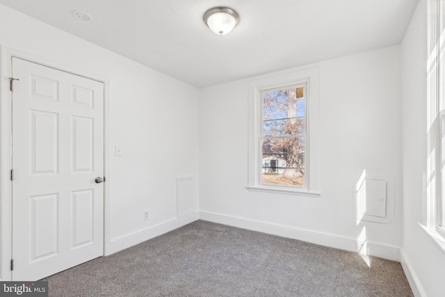 carpeted empty room with baseboards