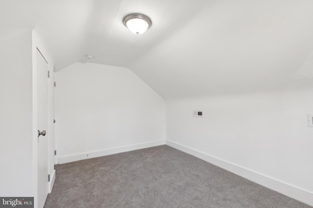 bonus room with lofted ceiling, baseboards, and carpet