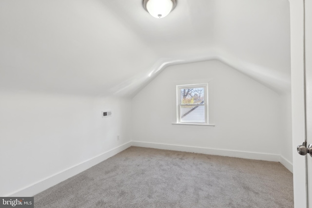 bonus room featuring lofted ceiling, visible vents, light carpet, and baseboards