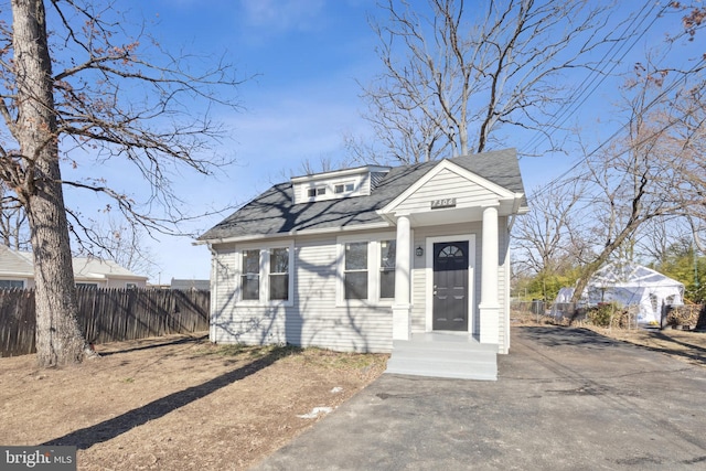 view of front of home featuring fence and roof with shingles