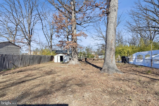 view of yard with an outbuilding, a shed, and fence