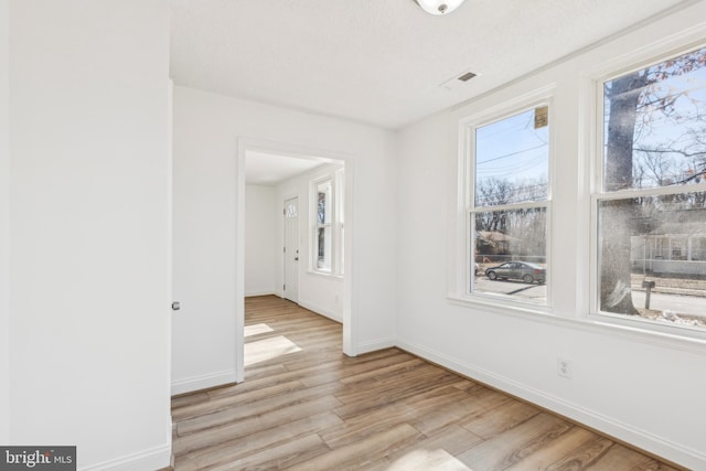 spare room with light wood finished floors and baseboards