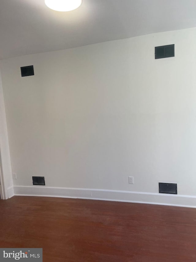 unfurnished room with dark hardwood / wood-style flooring