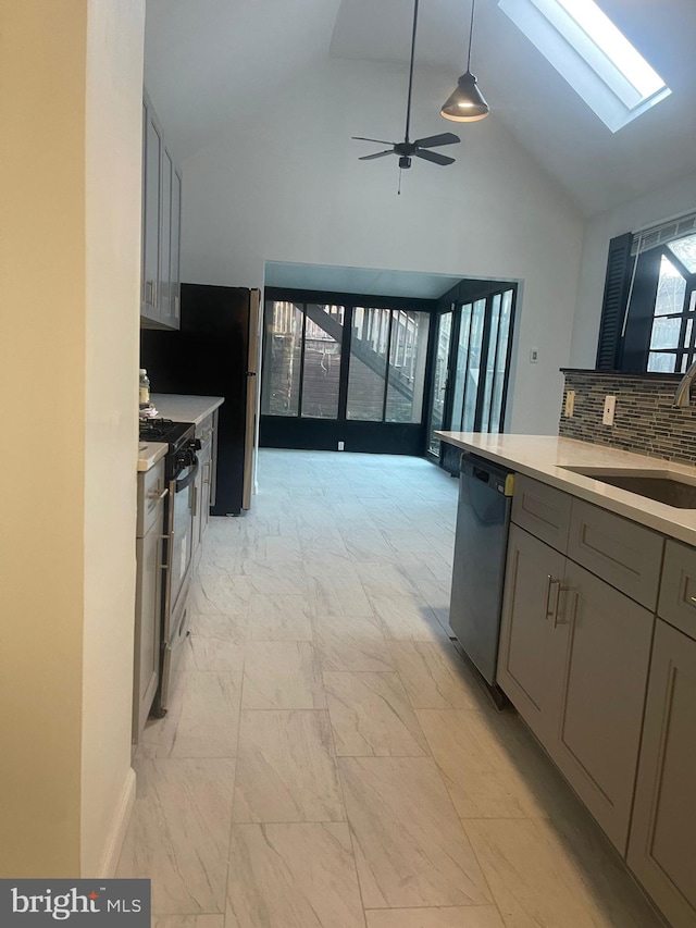 kitchen with gray cabinets, appliances with stainless steel finishes, pendant lighting, a skylight, and sink