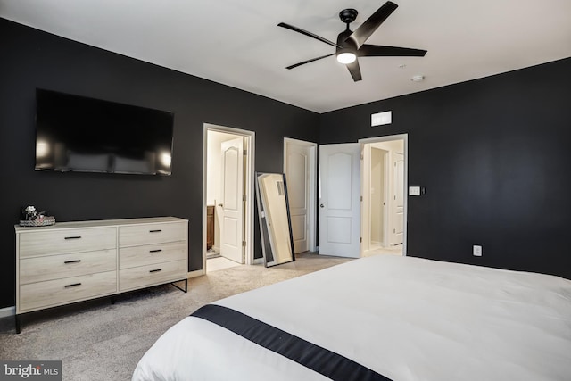 carpeted bedroom with connected bathroom and ceiling fan