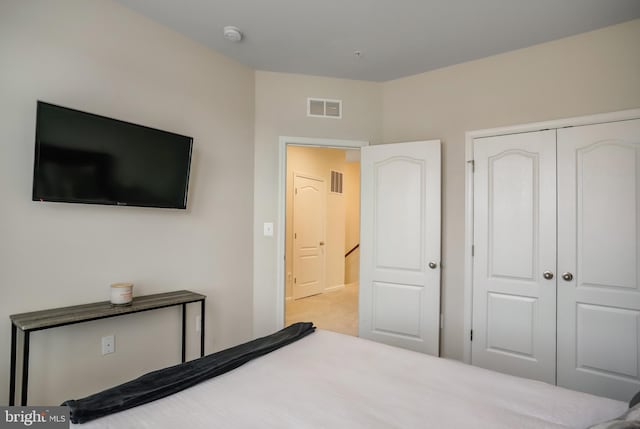 bedroom featuring light carpet and a closet