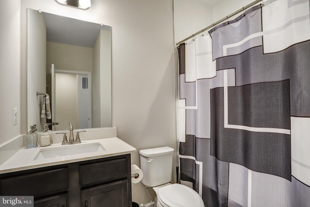 bathroom featuring vanity, toilet, and walk in shower