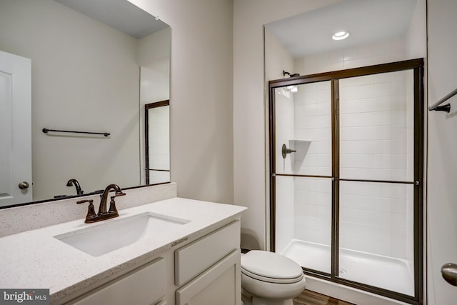 bathroom with vanity, toilet, and an enclosed shower