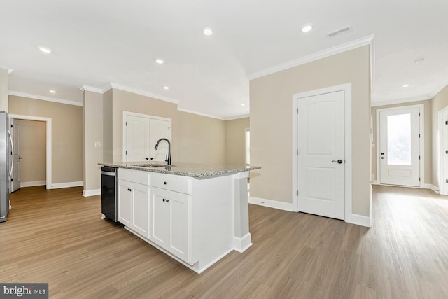 kitchen featuring light stone counters, a center island with sink, white cabinets, a sink, and dishwashing machine