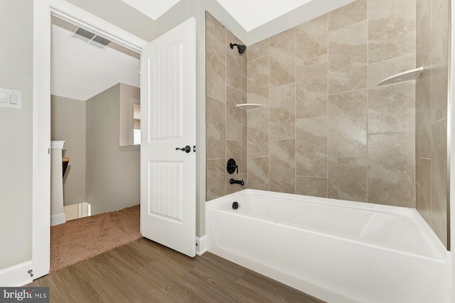 bathroom featuring visible vents, shower / tub combination, and wood finished floors