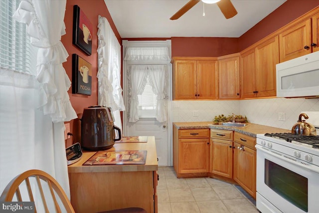 kitchen featuring sink, backsplash, white appliances, and ceiling fan