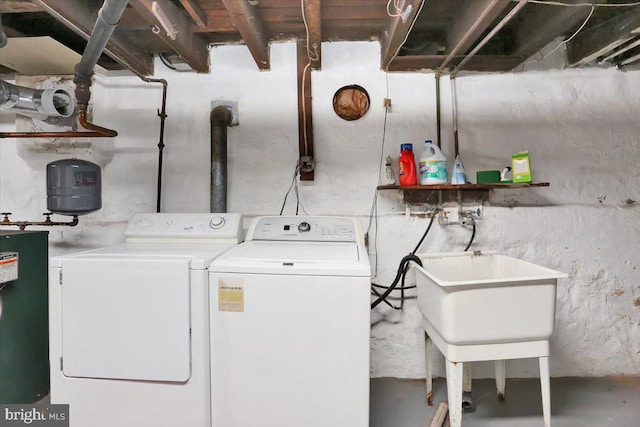 clothes washing area featuring sink, washer and dryer, and water heater