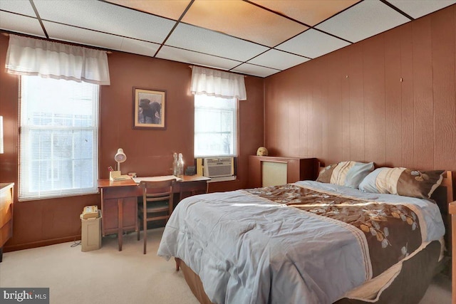 bedroom featuring multiple windows, carpet floors, cooling unit, and a drop ceiling