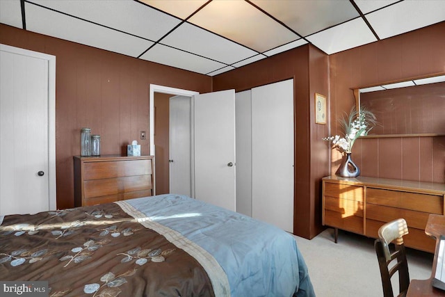 carpeted bedroom featuring a paneled ceiling and a closet