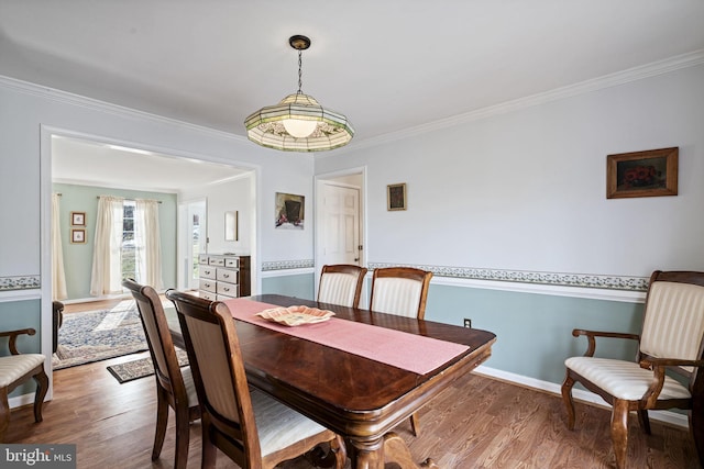 dining space featuring hardwood / wood-style flooring and ornamental molding