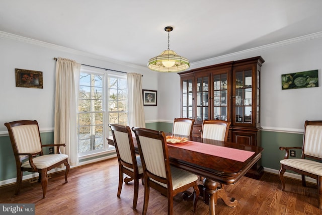 dining area with hardwood / wood-style flooring and ornamental molding