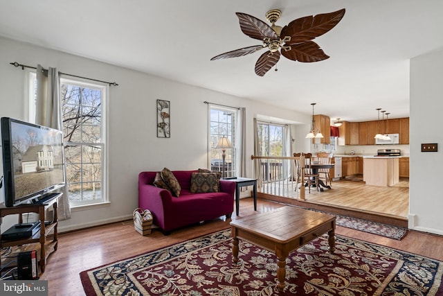 living room featuring light hardwood / wood-style flooring and ceiling fan