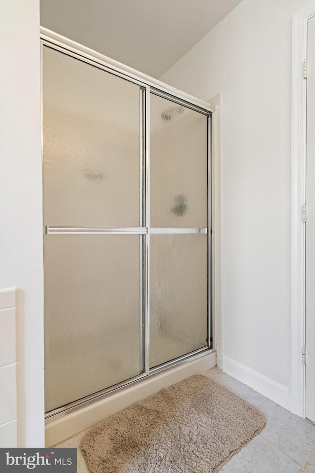 bathroom with tile patterned flooring and a shower with door