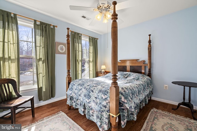 bedroom featuring multiple windows, dark hardwood / wood-style floors, and ceiling fan