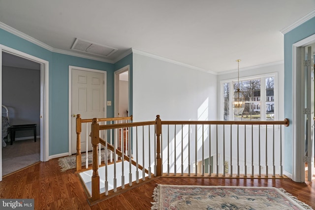 hall featuring crown molding, wood-type flooring, and a chandelier