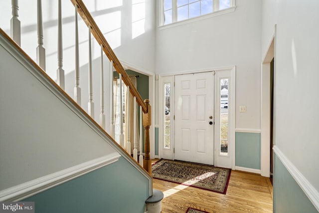 foyer with light hardwood / wood-style flooring and a high ceiling