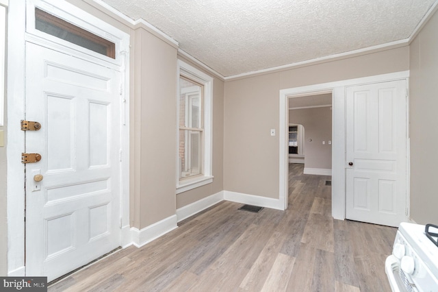 entryway featuring ornamental molding, a textured ceiling, and light hardwood / wood-style floors