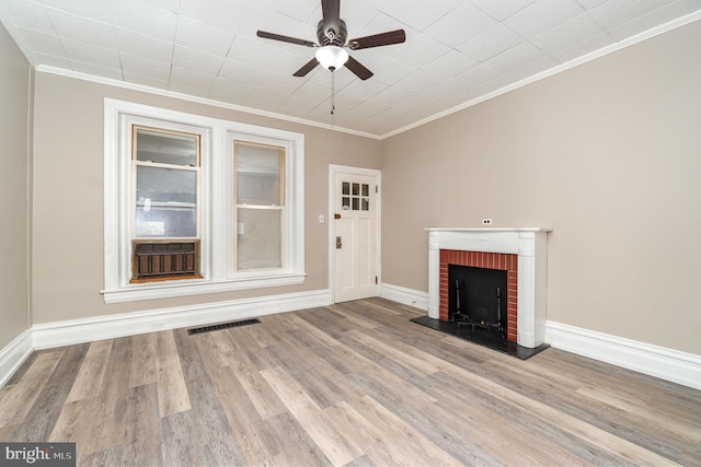 unfurnished living room with crown molding, a fireplace, light hardwood / wood-style floors, and ceiling fan