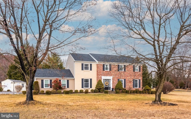 colonial house with brick siding and a front lawn