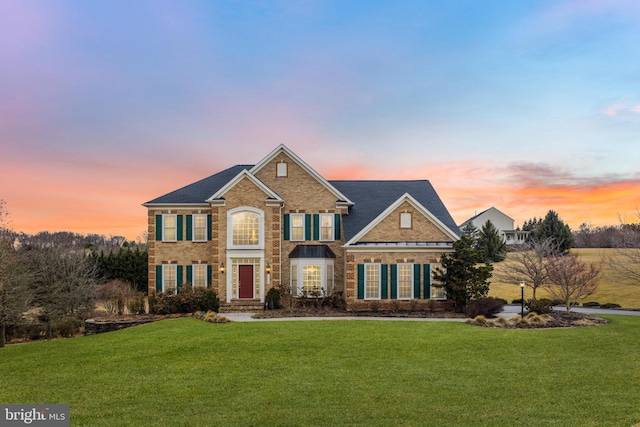 view of front of property featuring brick siding and a front lawn