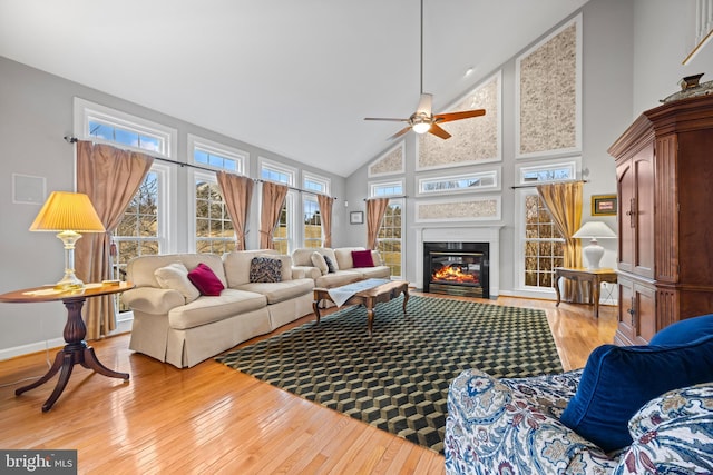 sunroom featuring a fireplace with flush hearth, lofted ceiling, and a ceiling fan