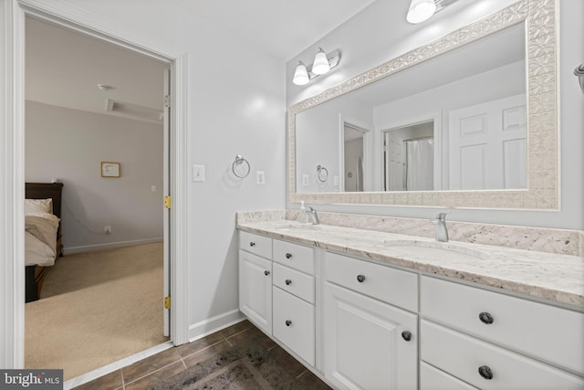 bathroom with double vanity, baseboards, a sink, and tile patterned floors