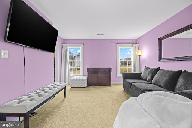 living area featuring light carpet, plenty of natural light, and visible vents