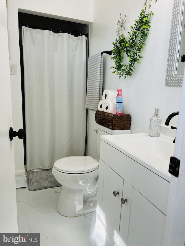 bathroom with toilet, marble finish floor, and vanity