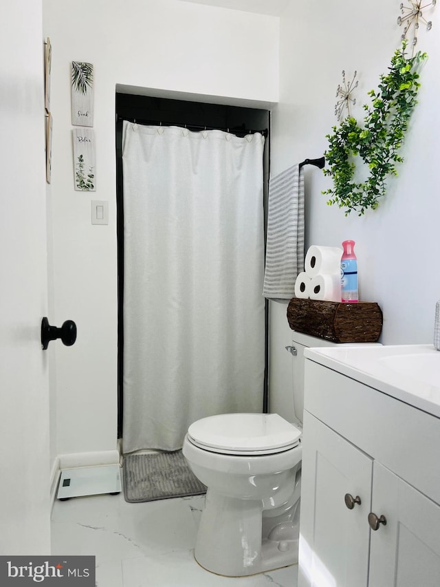 bathroom with marble finish floor, vanity, and toilet