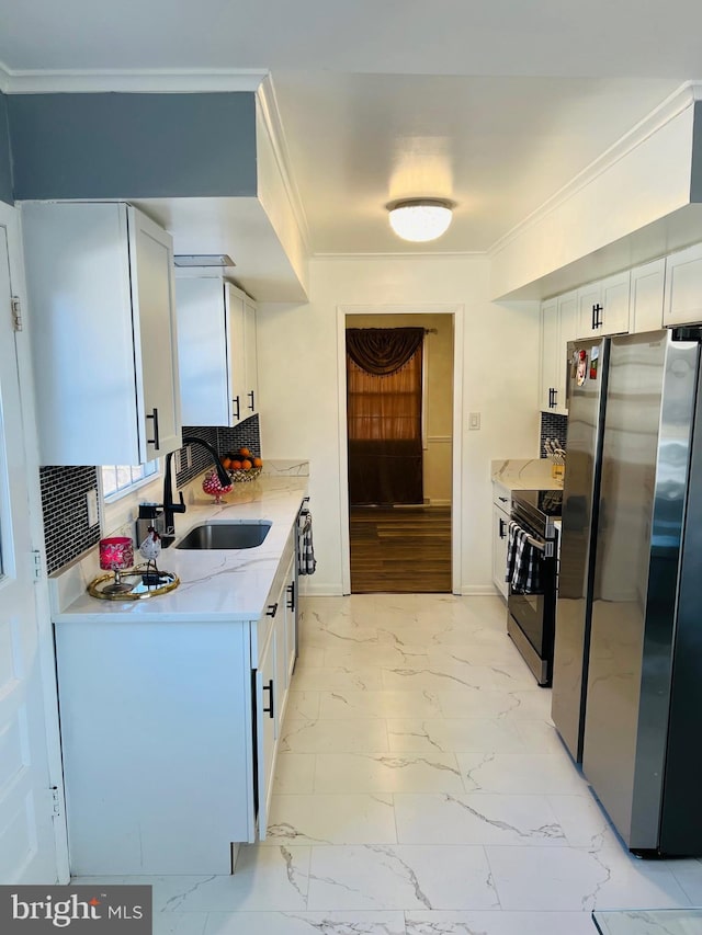 kitchen with electric range oven, light countertops, freestanding refrigerator, and white cabinetry