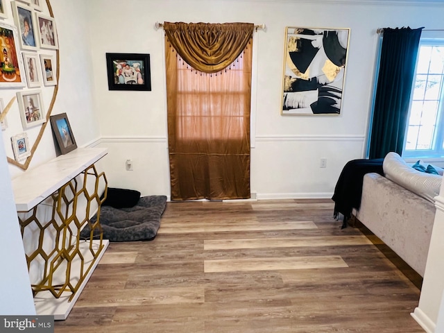 living area with baseboards and wood finished floors