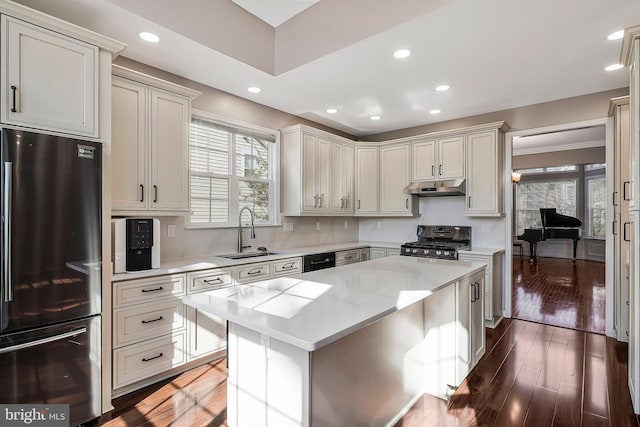 kitchen with dark wood-type flooring, sink, range, stainless steel fridge, and a kitchen island