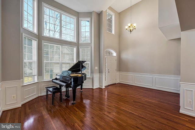 miscellaneous room with a notable chandelier and dark wood-type flooring