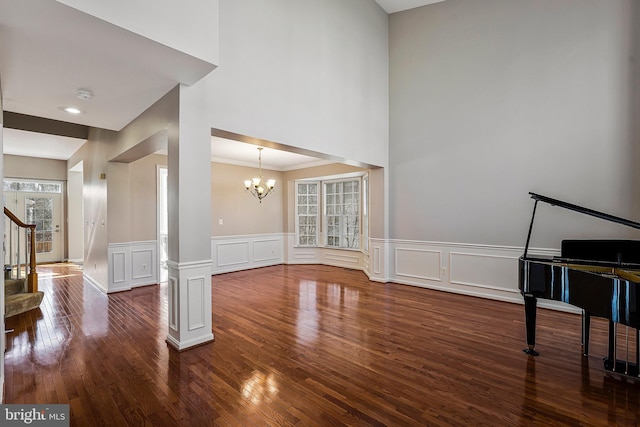 living room featuring crown molding, dark hardwood / wood-style floors, and a notable chandelier