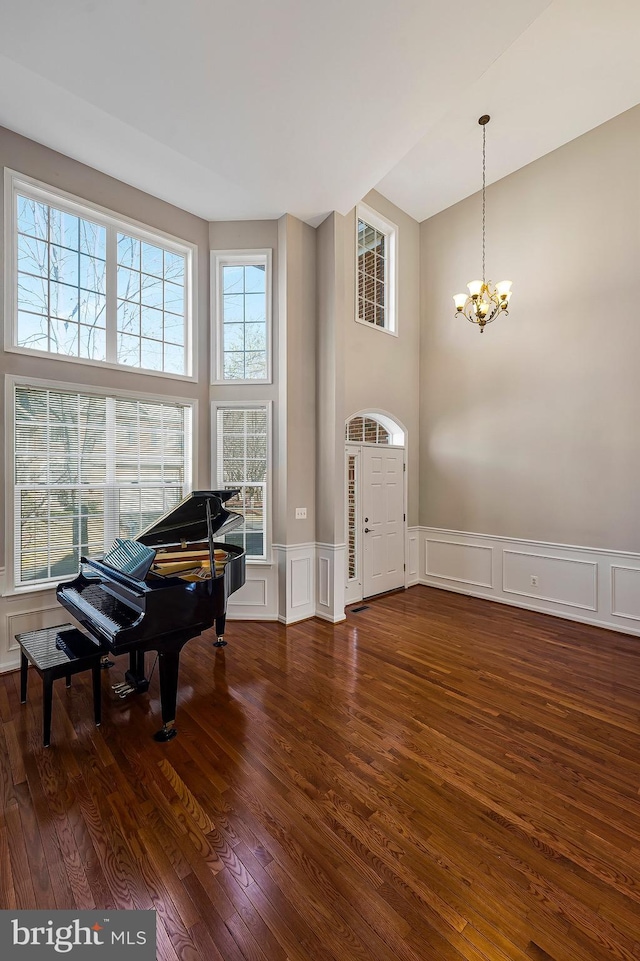 entrance foyer featuring dark hardwood / wood-style flooring, a towering ceiling, and a chandelier