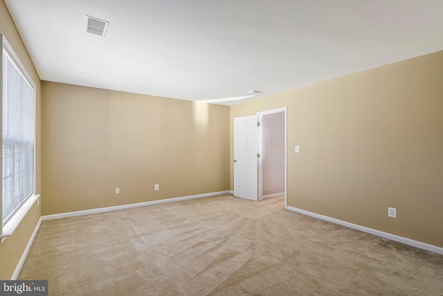 spare room with light colored carpet and a healthy amount of sunlight