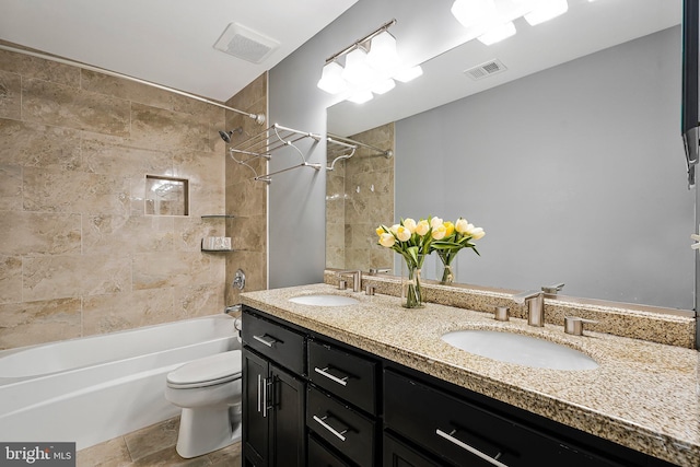 full bathroom featuring tiled shower / bath combo, vanity, and toilet