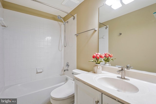 full bathroom with tiled shower / bath, vanity, and toilet