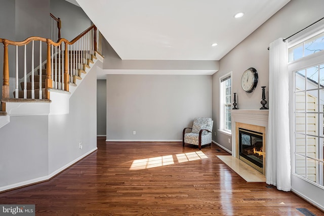 unfurnished living room featuring dark wood-type flooring and a fireplace